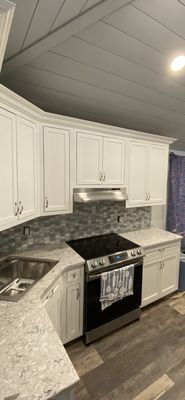 In this kitchen the cabinets were custom built, installed and sprayed along with a new backsplash.