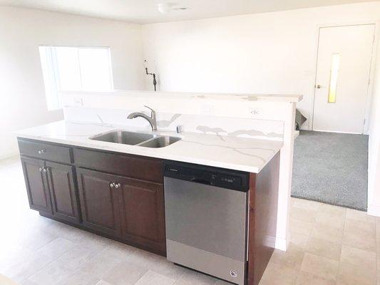 Kitchen with quartz counter tops, all new appliances and new windows with breakfast bar.