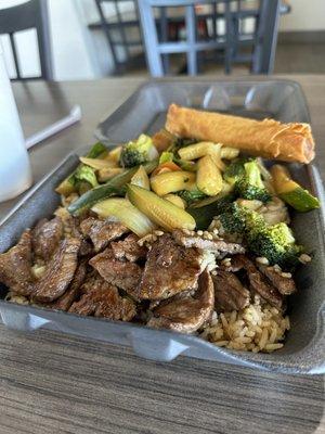 Hibachi steak with fried rice and vegetables with a spring roll