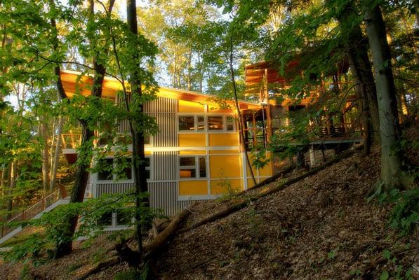 Set in a steep wooded area this artist's studio stands nestled as a modern tribute within nature.