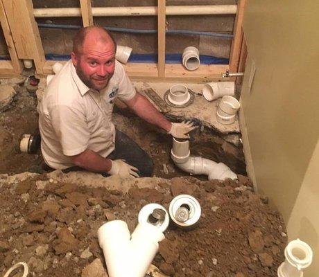 One of our plumbers going deep under basement slab to reroute pipes due to root intrusion.