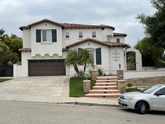 Fresh paint on the stucco, eaves, shutters, iron, and garage doors