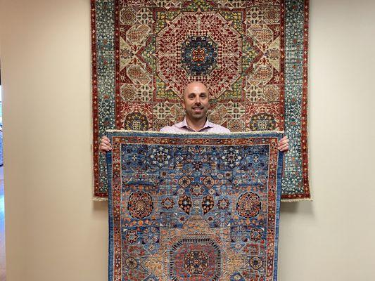 Our showroom manager showcasing 2 new hand knotted wool rugs.