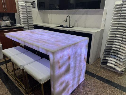 Part of our showroom showcasing a sample kitchen with an illuminated waterfall island