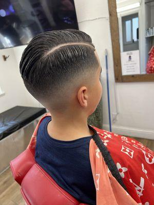 Drop fade with comb over and hard part.