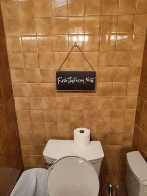 Amazing bathroom with flush the fing toilet sign