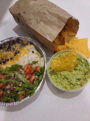 Steak burrito, guacamole and chips.