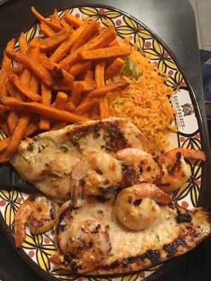 Chicken breast topped with shrimp. Sides are Mexican rice and sweet potato fries.