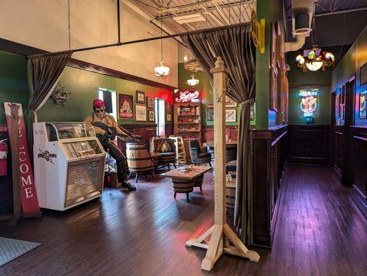 Looking from the corner of the bar: games & juke box to the left and restrooms to the left.