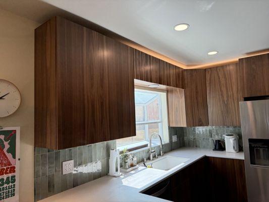 Custom walnut kitchen with Corian counter top and slatted overhead cabinets