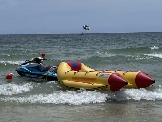 Banana boat and jet ski. Parasail boat in background.