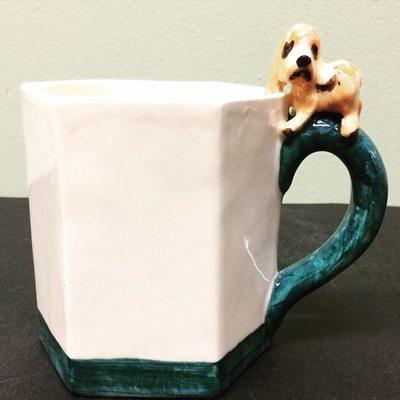 Hexagon mug with a hush puppy on handle.