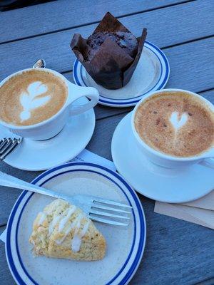 Lemon scone, chocolate muffin and decaf cappuccinos with extra foam and cinnamon