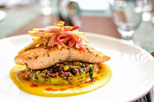 Grilled Salmon over a bed of quinoa salad and citrus turmeric sauce.