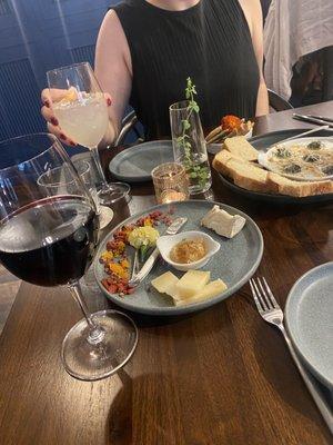 Glass of Grenache, glass of lemon spritz, Little Lucy Brie and aged sheep milk cheeses, escargot in garlic butter with gf sourdough bread