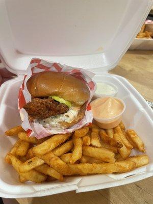 Chicken sandwich combo with fries and two sauces.