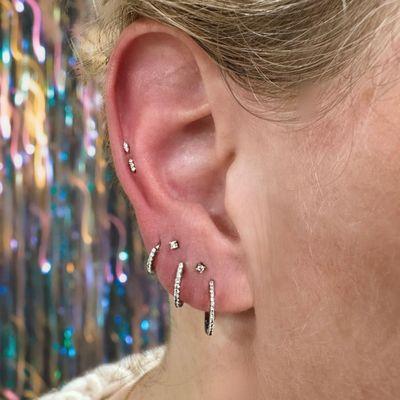 Lobe and cartilage piercings by Erika Fries.