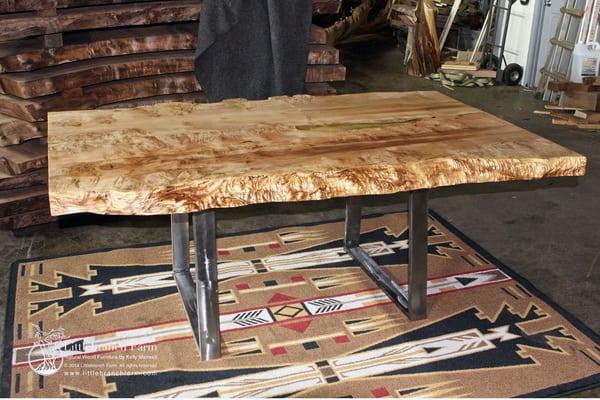 Organic wood slab dining table with metal base and natural live edge wood slab.