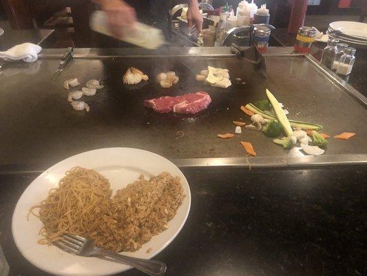 Steak, lobster, shrimp, scallops, and calamari with rice, noodles and veggies