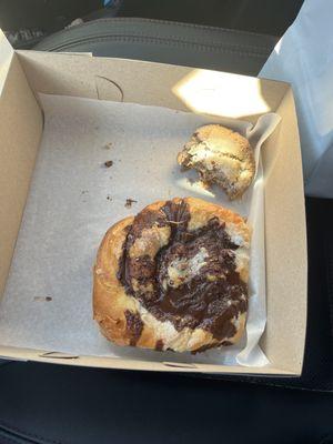 Half eaten cinnamon raisin scone and chocolate danish.