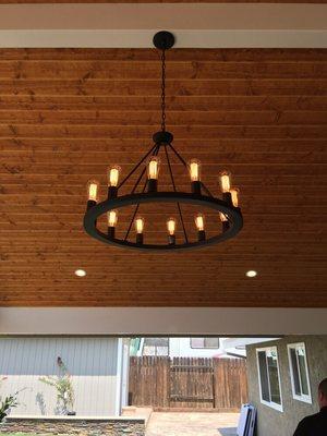 Recessed lighting and chandelier in patio cover