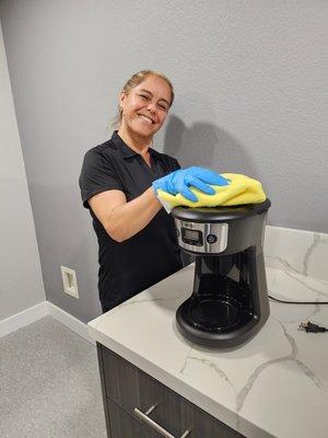 Araceli, cleaning a coffee maker at one of our Orange projects.