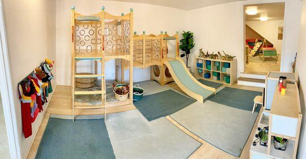 One of the interior rooms of our indoor playspace area at Eagle Rock, featuring costumes, climbing structure, kitchen, blocks, and more