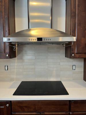 A new quartz countertop paired with a stylish porcelain backsplash.