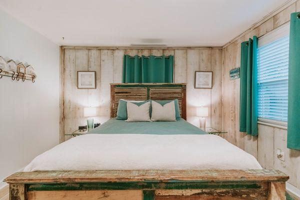 Queen bed with tv in first bedroom in Bellande Cottage