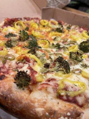 Small vegan pizza with broccoli, banana peppers and green olives.