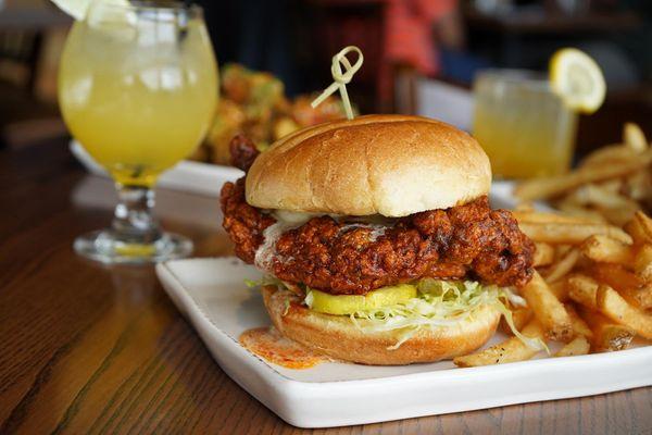 Buttermilk fried chicken, Nashville hot seasoning, lettuce, pickles, and honey butter on a potato bun.