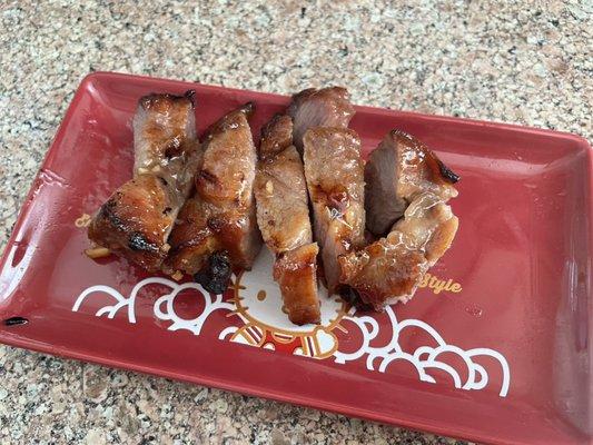 Homemade BBQ pork is being prepared. It will be cut into bite-sized pieces for toddlers to eat.