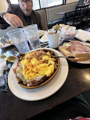 Farmers skillet with toast. Skillet is corned beef hash. Eggs are scrambled. Hash has delicious peppers