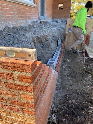 Brick wall damage being rebuilt