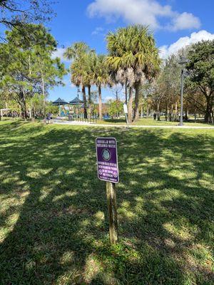 Sign and view of playgrounds from parking lot