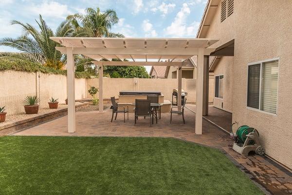 Artificial turf, pavers, and aluminum pergola.  Includes low voltage lighting.  Previously the ground sloped toward the house.