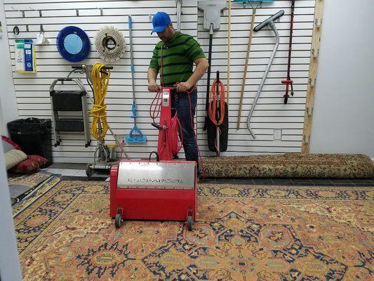 Rug "dusting" with a rug badger machine in our own facility.