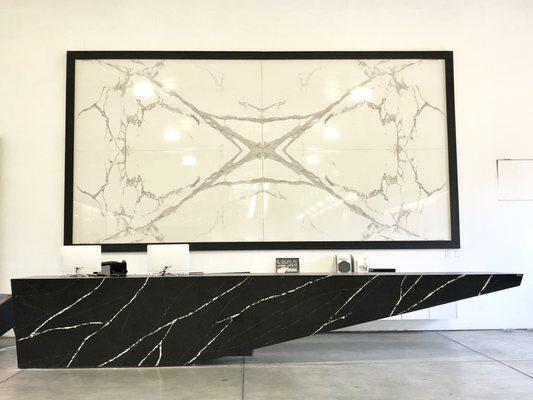 Bookmatched porcelain slabs on the wall and a gigantic quartz reception desk to start off your tour!