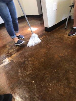 Lady cleaning g the floor under our feet