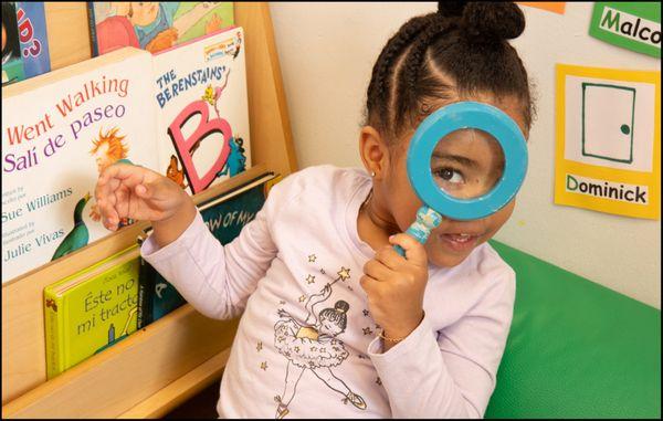 Child looking through magnifying glass