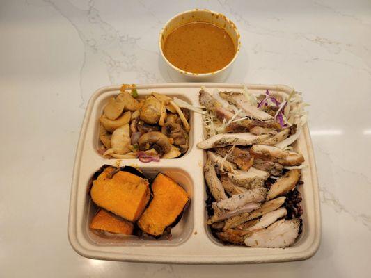 base of riceberry and cabbage, lemongrass chicken, massaman curry on the side, sides of sweet potato with coconut butter and larb mushroom