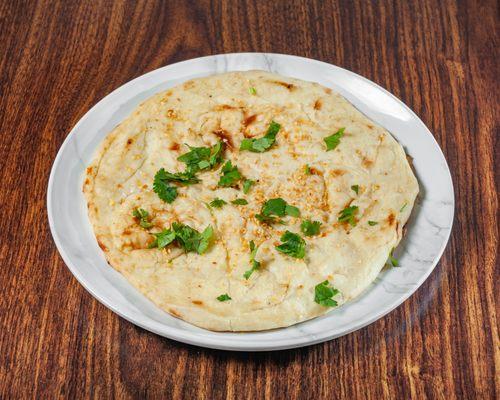 "Indulge in the rich flavors of our Clay Oven Butter and Garlic Naan - a perfect pairing for any dish!"