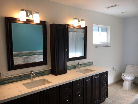 Master bathroom cabinets with quartz countertop and glass tile back splash