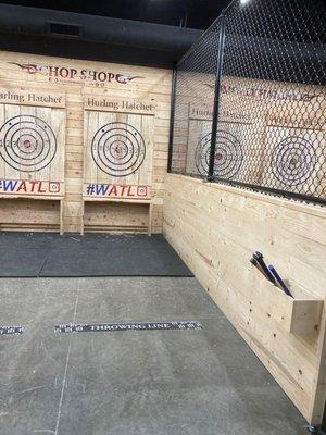 One stall, including the axe bucket for one lane and the fence/wall between it and the next stall