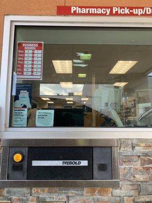 Pharmacy drive-thru with hours open posted.