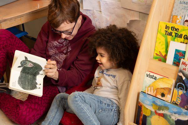 Teacher reads book with child in 4s classroom