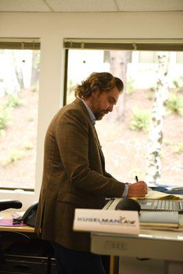 Making notes in the office at his standing desk.