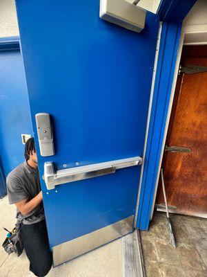 FlyLock Orange County technician providing locksmith services, completing an exit device installation