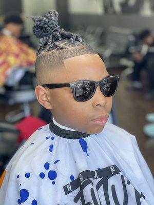 Bald fade with braids on top.