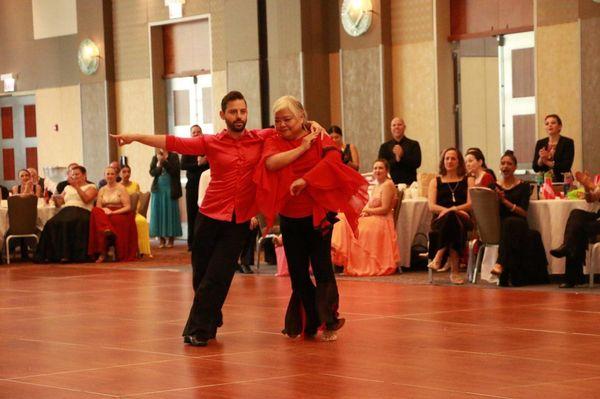 Norine dancing her Merengue routine with her instructor during our Casino Royale Showcase in Fall 2019.